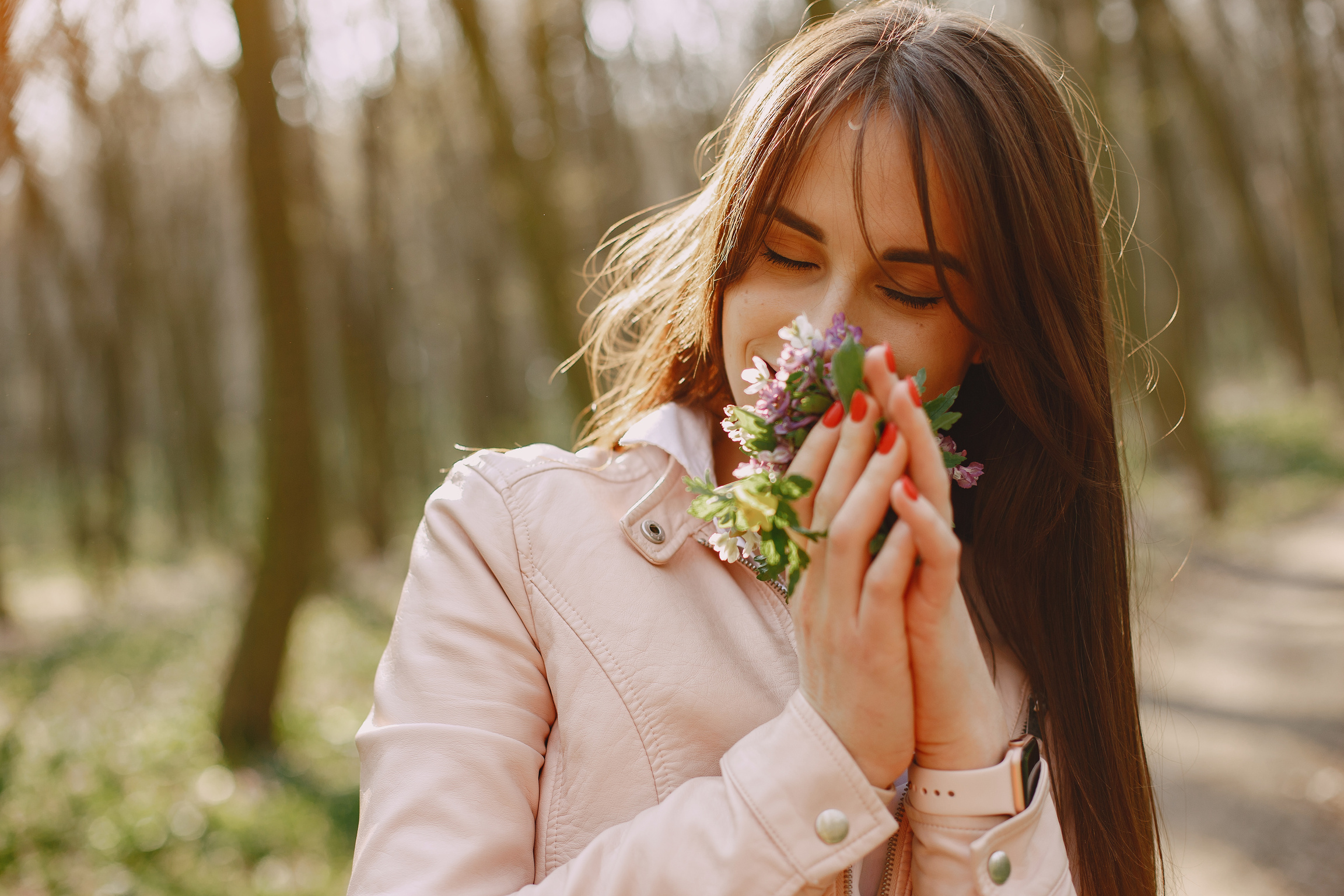 Young Woman Smelling Flowers in the Forest